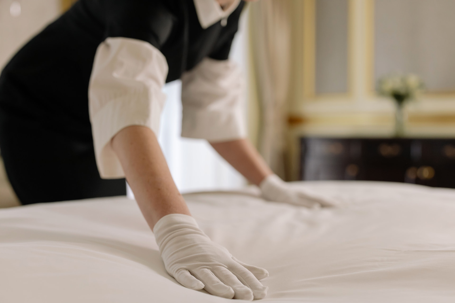 Professional cleaner preparing a guest bedroom between short-let stays